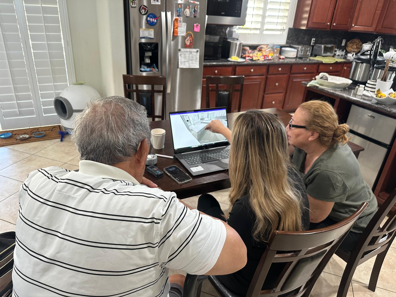 Reviewing a 3D kitchen design with clients at their home