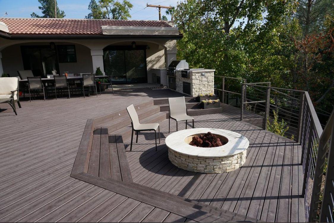 Completed deck with stone fire pit and outdoor kitchen