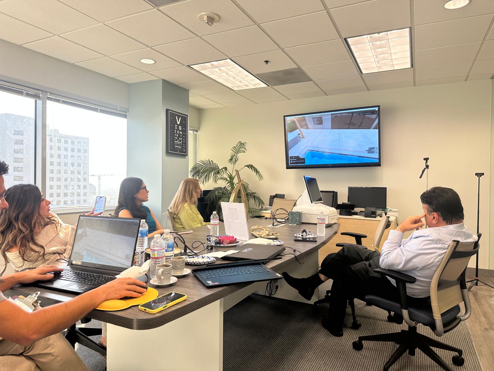 Team reviewing a 3D pool and patio design in the office